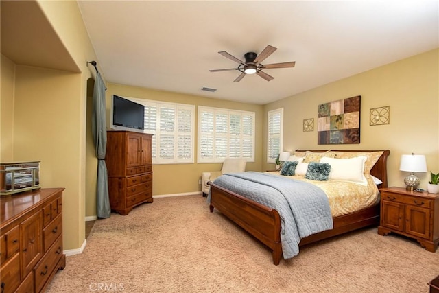bedroom with visible vents, light colored carpet, baseboards, and ceiling fan