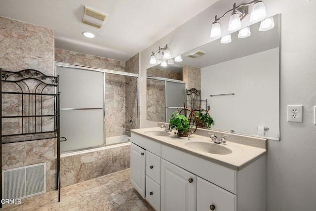 full bath with visible vents, a sink, and tiled shower / bath