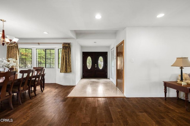 entryway with recessed lighting, wood finished floors, and a notable chandelier