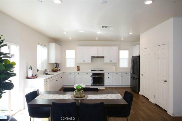27464 Honeydew Ct, Saugus, CA 91350 - kitchen featuring stove, freestanding refrigerator, a sink, under cabinet range hood, and white cabinets