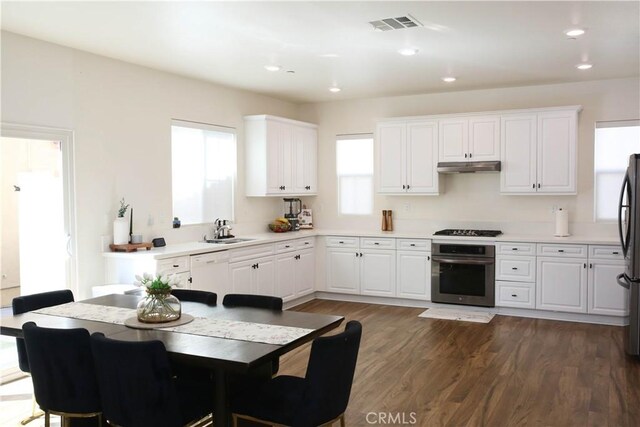 27464 Honeydew Ct, Saugus, CA 91350 - kitchen with stainless steel oven, a sink, under cabinet range hood, black gas stovetop, and dark wood-type flooring