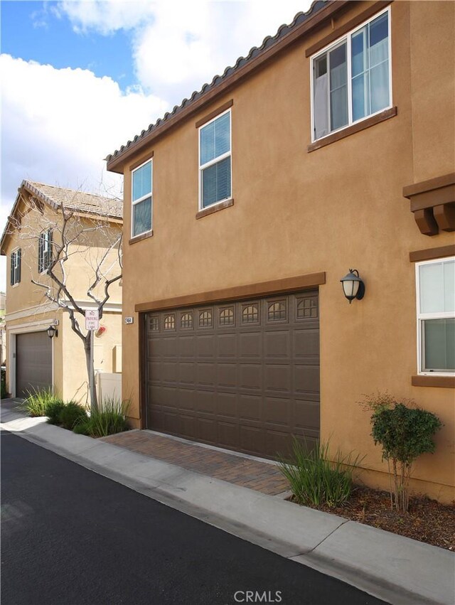27464 Honeydew Ct, Saugus, CA 91350 - view of front facade featuring a garage, stucco siding, driveway, and a tile roof