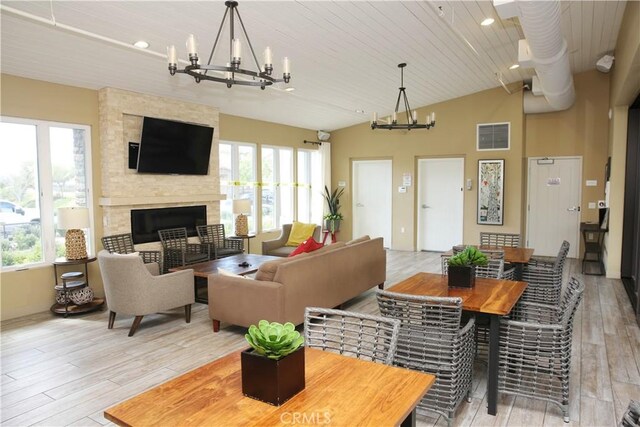 27464 Honeydew Ct, Saugus, CA 91350 - living room with a chandelier, light wood-type flooring, plenty of natural light, a fireplace, and vaulted ceiling