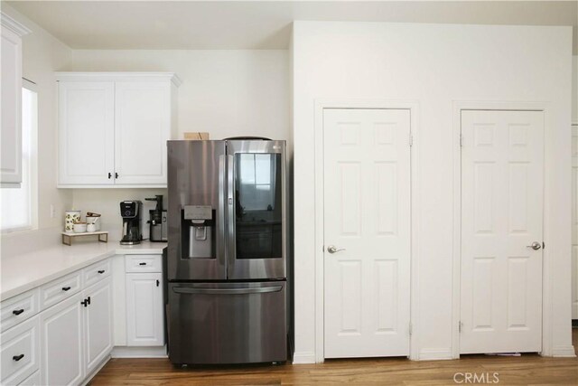 27464 Honeydew Ct, Saugus, CA 91350 - kitchen with stainless steel refrigerator with ice dispenser, white cabinetry, wood finished floors, and light countertops