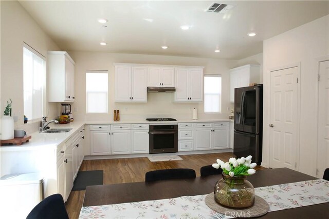 27464 Honeydew Ct, Saugus, CA 91350 - kitchen with black appliances, a sink, under cabinet range hood, white cabinets, and light wood finished floors