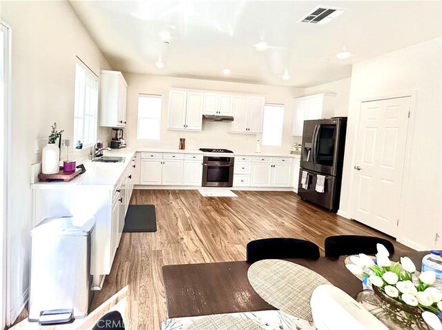 27464 Honeydew Ct, Saugus, CA 91350 - kitchen featuring stainless steel fridge with ice dispenser, stove, a sink, light wood-style floors, and under cabinet range hood