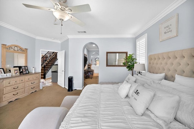 carpeted bedroom featuring arched walkways, visible vents, a spacious closet, ornamental molding, and baseboards