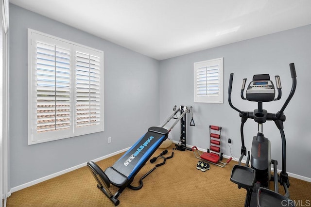 workout area featuring baseboards and carpet flooring