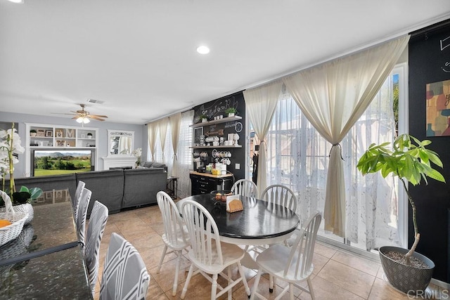 dining space featuring a ceiling fan, visible vents, plenty of natural light, and light tile patterned floors