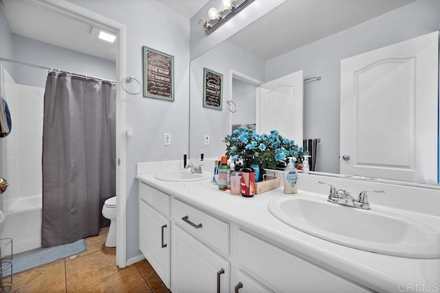 full bathroom with double vanity, tile patterned flooring, a sink, and toilet