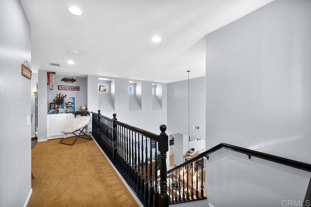 corridor featuring baseboards, visible vents, carpet flooring, an upstairs landing, and recessed lighting