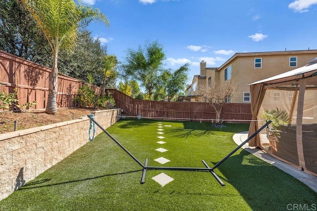 view of yard with a fenced backyard and a gazebo