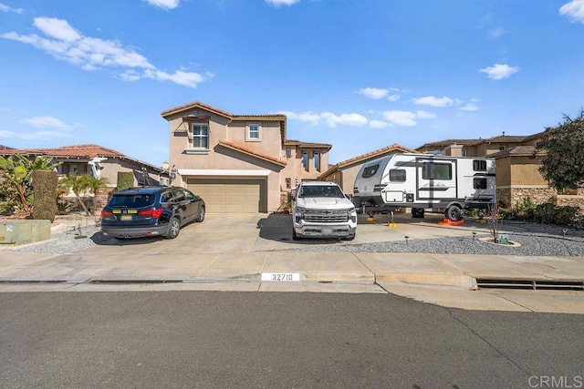 view of front of property featuring a garage, driveway, a tile roof, and stucco siding