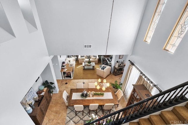 interior space featuring visible vents, stairway, an inviting chandelier, and tile patterned floors