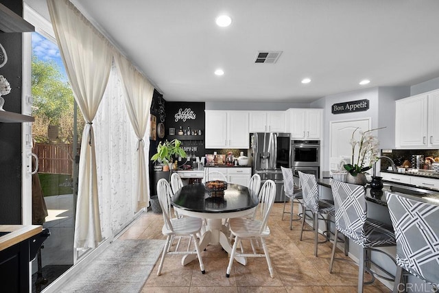 kitchen with recessed lighting, white cabinetry, visible vents, appliances with stainless steel finishes, and tasteful backsplash