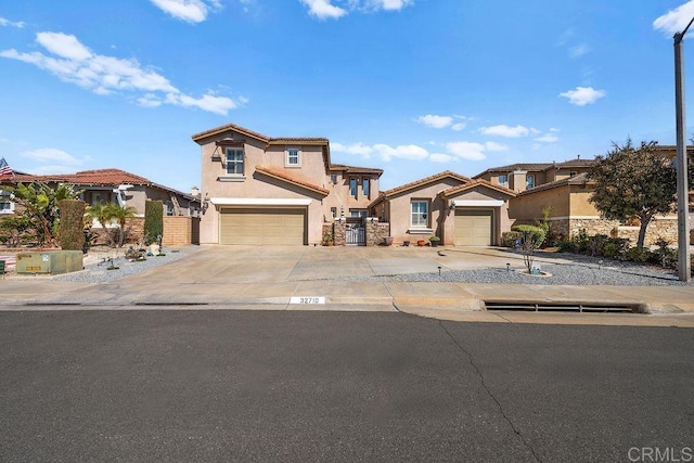 mediterranean / spanish home with driveway, fence, and stucco siding