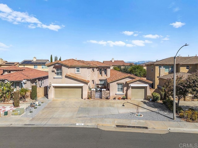 mediterranean / spanish home with a garage, a tiled roof, a residential view, and stucco siding