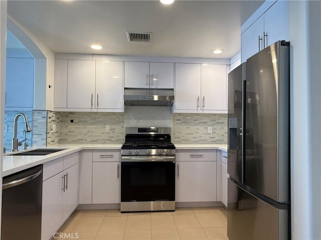 kitchen with under cabinet range hood, a sink, visible vents, light countertops, and appliances with stainless steel finishes