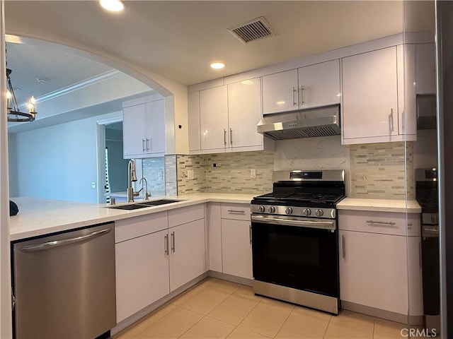 kitchen with visible vents, white cabinets, appliances with stainless steel finishes, under cabinet range hood, and a sink