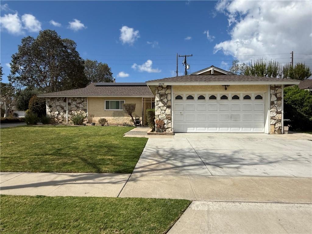 single story home featuring stone siding, driveway, a front lawn, and an attached garage