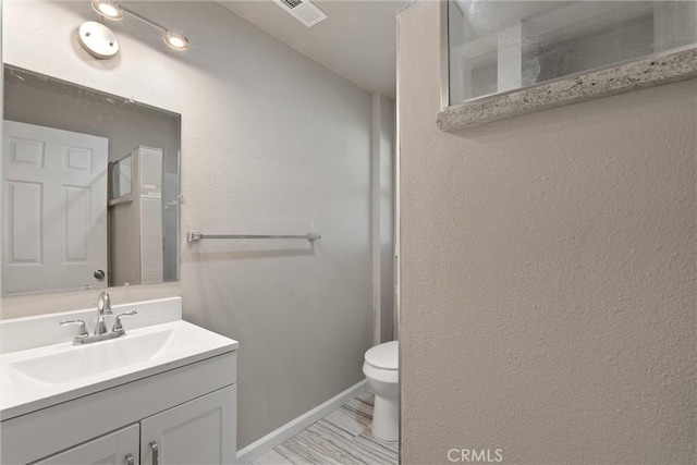 812 Toomes Ave, Corning, CA 96021 - bathroom with toilet, visible vents, baseboards, and vanity