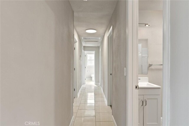 812 Toomes Ave, Corning, CA 96021 - hallway with a sink, baseboards, light tile patterned floors, and visible vents