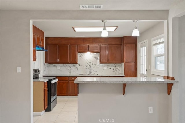 812 Toomes Ave, Corning, CA 96021 - kitchen with under cabinet range hood, a sink, a peninsula, black range with electric cooktop, and tasteful backsplash
