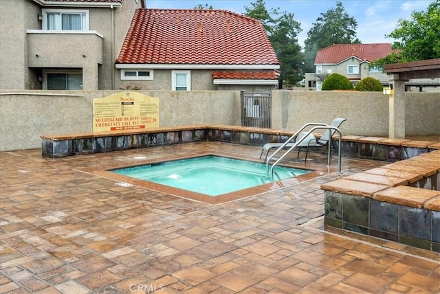 view of swimming pool featuring a patio area, a hot tub, and fence