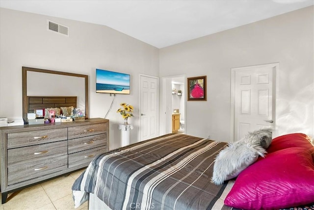 bedroom with lofted ceiling, visible vents, ensuite bathroom, and light tile patterned flooring