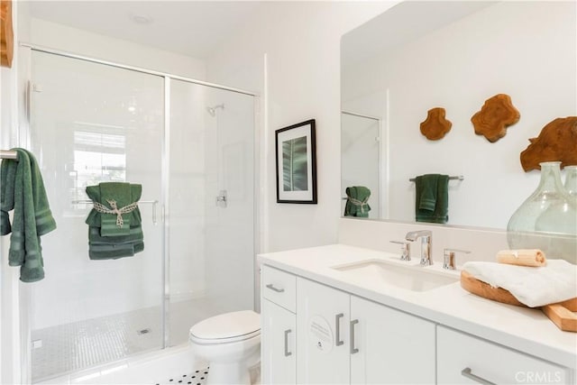 bathroom with a stall shower, toilet, and vanity