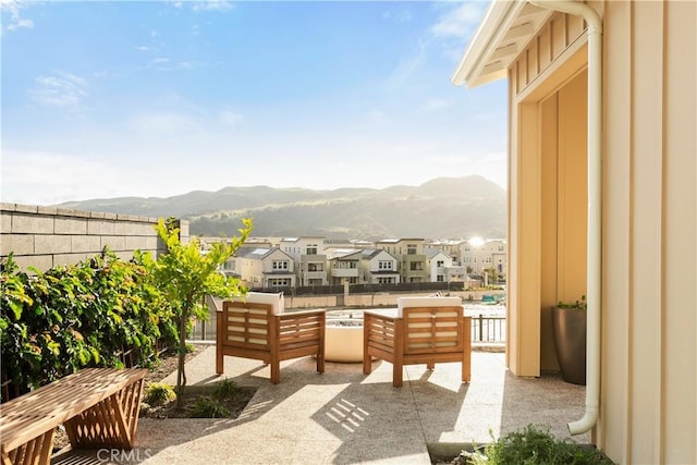 view of patio / terrace featuring a residential view, a mountain view, and fence