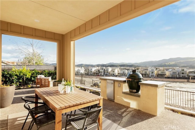 view of patio featuring a grill, outdoor dining area, fence, and a residential view