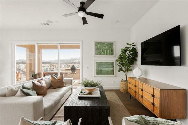 living room featuring dark wood-style floors, visible vents, and ceiling fan