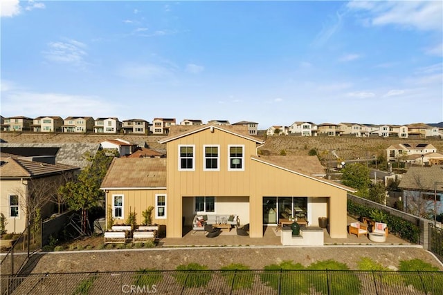 rear view of house featuring outdoor lounge area, a residential view, a fenced backyard, and a patio