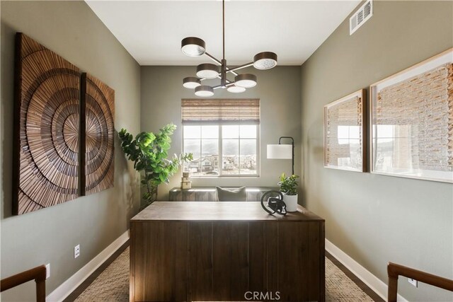 office featuring baseboards, visible vents, and a notable chandelier