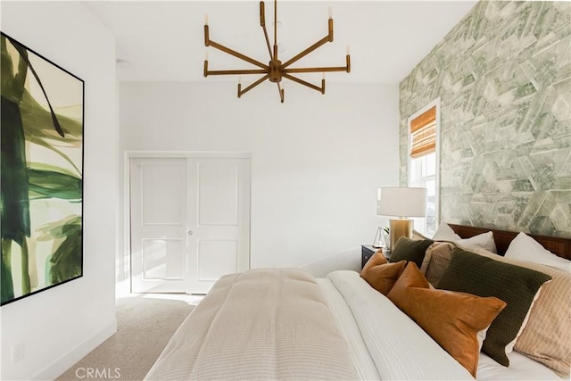 carpeted bedroom with a notable chandelier and a closet