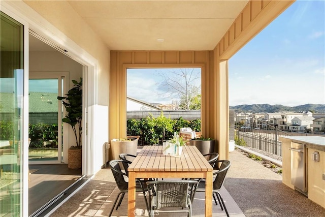 sunroom with a residential view, a mountain view, and a healthy amount of sunlight