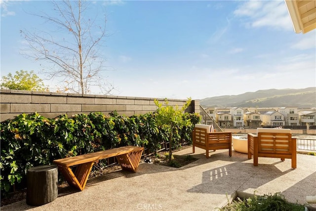 view of patio / terrace featuring a fenced backyard, a mountain view, and a residential view