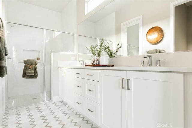 full bathroom with double vanity, a sink, and a stall shower