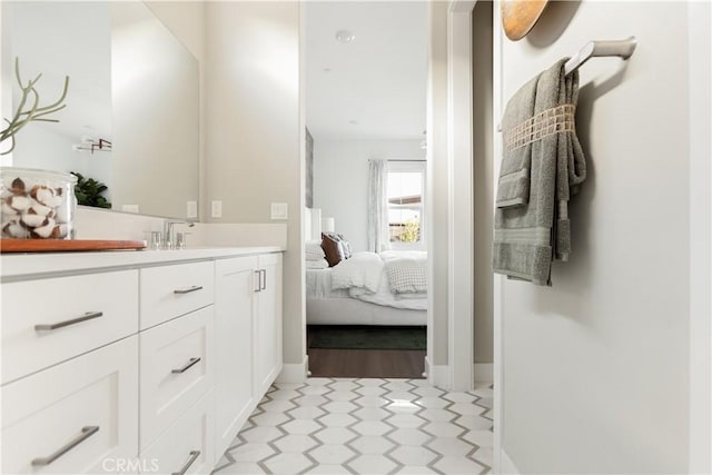 bathroom with tile patterned floors, vanity, connected bathroom, and baseboards