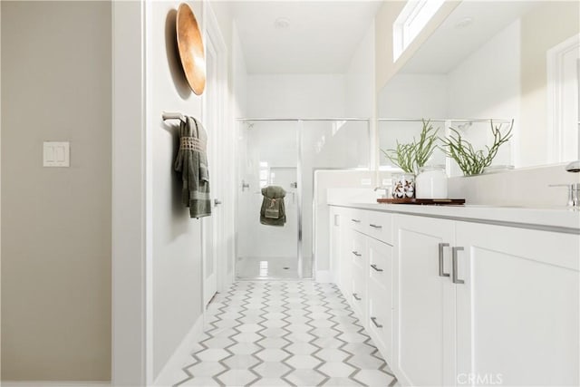 bathroom with a shower stall, a sink, and double vanity