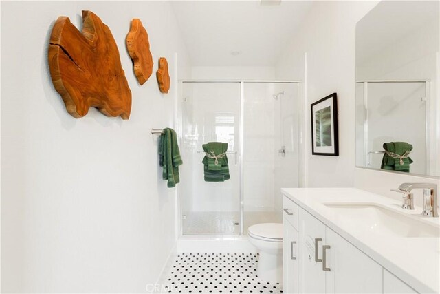 full bathroom featuring a stall shower, tile patterned floors, toilet, and vanity