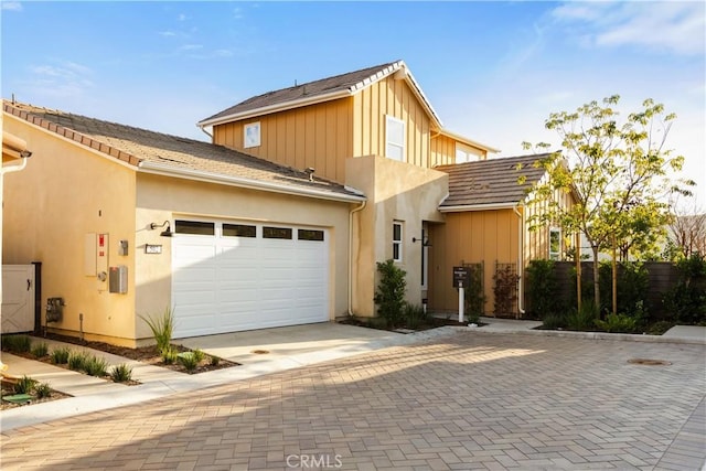 view of front of home with driveway, stucco siding, and a garage