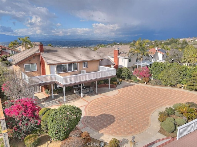 view of front of home with a tile roof, a patio area, and stucco siding