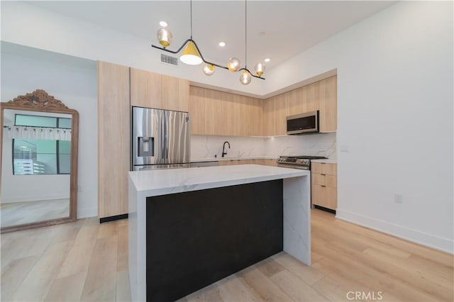 kitchen featuring modern cabinets, stainless steel appliances, and light brown cabinetry