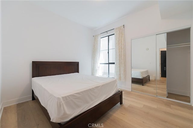 bedroom with light wood-style flooring and baseboards