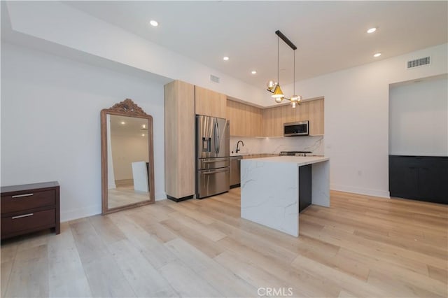 kitchen featuring light wood-style flooring, visible vents, light countertops, appliances with stainless steel finishes, and modern cabinets