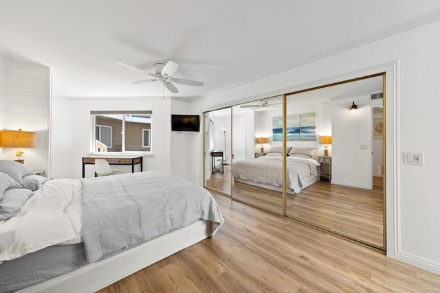 bedroom featuring a ceiling fan, light wood-type flooring, a closet, and baseboards