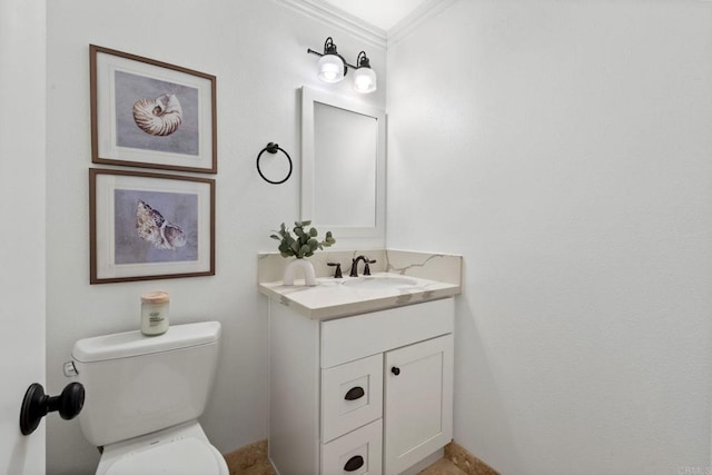 bathroom featuring ornamental molding, vanity, and toilet