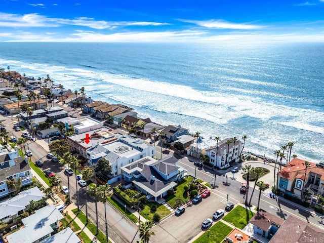drone / aerial view with a beach view, a residential view, and a water view